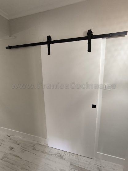 Puerta corredera interior lacada blanca mate con herraje negro granero y tirador embutido instalada por FRANISA en Valladolid